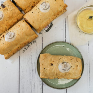 Cheese and pickle sausage rolls with a pot of mustard.