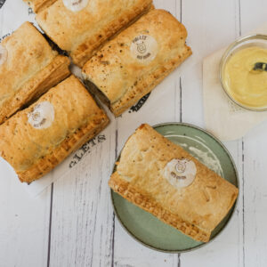 Red onion sausage rolls with a pot of mustard