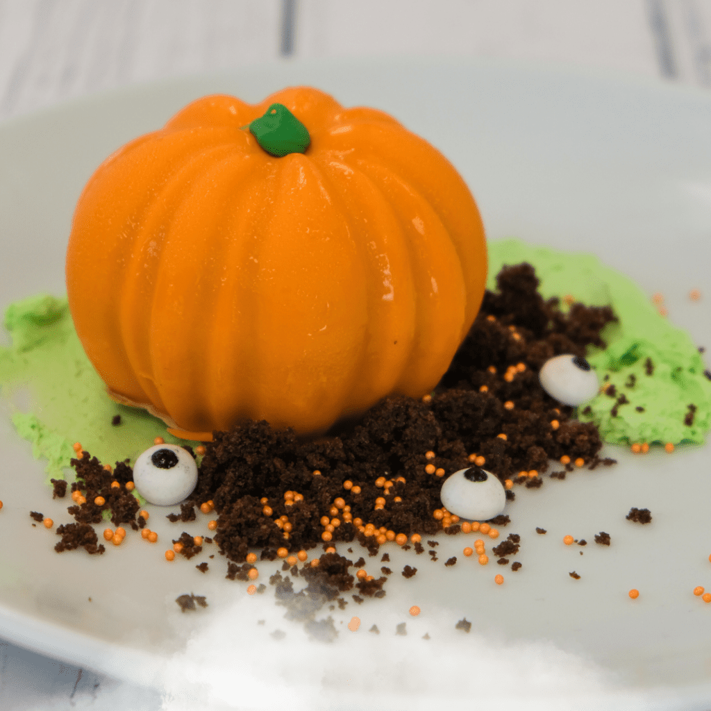 A pumpkin shaped dessert on a white plate