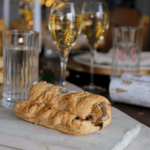A sausage roll on a white chopping board